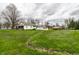 Lush backyard showcasing the white house, sheds, and mature trees in a serene setting at 359 N Whitcomb Ave, Indianapolis, IN 46224
