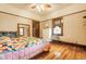 Charming bedroom featuring hardwood floors, bright windows, and a cozy quilt-covered bed at 359 N Whitcomb Ave, Indianapolis, IN 46224