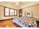 Bright bedroom featuring gleaming hardwood floors, natural light, and a colorful quilt on the bed at 359 N Whitcomb Ave, Indianapolis, IN 46224