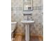 Charming half-bath with pedestal sink, tile backsplash and floors, and modern fixtures at 3638 Redfern Dr, Indianapolis, IN 46237