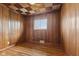 Inviting bedroom featuring wood paneling, hardwood floors, and bright window at 3638 Redfern Dr, Indianapolis, IN 46237
