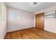 Bedroom features hardwood floors, a window for natural light, closet, and a wall mirror at 3638 Redfern Dr, Indianapolis, IN 46237