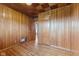 Cozy bedroom featuring wood-paneled walls, hardwood floors, and warm lighting at 3638 Redfern Dr, Indianapolis, IN 46237