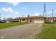 Well-maintained single-story home featuring stone accents, an attached garage, and a gravel driveway at 3638 Redfern Dr, Indianapolis, IN 46237
