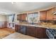Well-equipped kitchen with dark wood cabinetry, stone countertops, and stainless steel appliances at 3638 Redfern Dr, Indianapolis, IN 46237