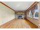 Warm living room featuring hardwood floors, a stone fireplace, and a window that provides natural light at 3638 Redfern Dr, Indianapolis, IN 46237