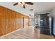 Inviting living room featuring wood paneling, modern refrigerator, and sleek laminate floors at 3638 Redfern Dr, Indianapolis, IN 46237