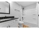 Bathroom featuring a white vanity with a black countertop and a shower-tub combo with black hardware at 401 Iowa St, Indianapolis, IN 46225