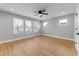 Sunny bedroom with wood-look floors, ceiling fan, and an abundance of natural light from three large windows at 401 Iowa St, Indianapolis, IN 46225