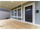 Inviting covered porch showcasing a stylish front door, neutral trim, and wood flooring at 401 Iowa St, Indianapolis, IN 46225