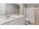 Bathroom featuring double vanity sinks, a quartz countertop, and a shower with a patterned curtain at 432 Bluestem Ln, Whiteland, IN 46184
