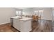 Open-concept kitchen and dining space with stainless steel appliances, white cabinets and island at 432 Bluestem Ln, Whiteland, IN 46184