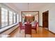 Dining area with window seat, wood trim, hardwood floor, and pendant lighting, open to the living area at 5139 Kingswood Dr, Carmel, IN 46033