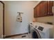 Functional laundry room with updated appliances, cabinets, and tile flooring at 5139 Kingswood Dr, Carmel, IN 46033