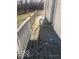 Side view of a weathered, uncovered wooden deck with a white railing leading to an entry door at 5657 E Fall Creek Pkwy N Dr, Indianapolis, IN 46226