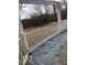 View of an elevated wooden deck with white railing showing wear and the surrounding wooded area at 5657 E Fall Creek Pkwy N Dr, Indianapolis, IN 46226