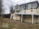View of the back of the home with an elevated deck and siding in need of repair at 5657 E Fall Creek Pkwy N Dr, Indianapolis, IN 46226