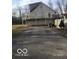 View of the rear of the house from the driveway, highlighting the elevated deck at 5657 E Fall Creek Pkwy N Dr, Indianapolis, IN 46226