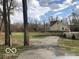 View of the home with a back yard and driveway from the side of the property at 5657 E Fall Creek Pkwy N Dr, Indianapolis, IN 46226