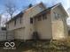 View of the side of the home with an exposed foundation and wood siding at 5657 E Fall Creek Pkwy N Dr, Indianapolis, IN 46226