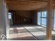 View of a room under construction with exposed framing, plywood flooring, and new windows installed at 5657 E Fall Creek Pkwy N Dr, Indianapolis, IN 46226