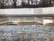 An in-ground pool sits with a wooden deck and white fence in a yard space ready for renovation at 5657 E Fall Creek Pkwy N Dr, Indianapolis, IN 46226
