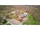 Aerial view showcasing this home with a pool and outbuilding nestled within lush greenery and mature trees at 6170 Shelbyville Rd, Indianapolis, IN 46237