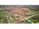 Aerial view of the property, lush landscape, mature trees, in-ground pool, and outbuilding in distance at 6170 Shelbyville Rd, Indianapolis, IN 46237