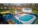 Aerial view showcasing a backyard with a pool, deck, sheds, a fenced yard, mature trees and lots of outdoor space at 6170 Shelbyville Rd, Indianapolis, IN 46237