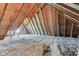 This attic features exposed rafters and insulation at 6170 Shelbyville Rd, Indianapolis, IN 46237