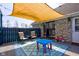Back patio featuring seating and a shade cover adjacent to stone exterior and well manicured garden at 6170 Shelbyville Rd, Indianapolis, IN 46237