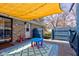 Back patio featuring seating and a shade cover adjacent to stone exterior and blue fence at 6170 Shelbyville Rd, Indianapolis, IN 46237