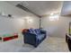 Finished basement features a cozy blue sofa, carpeted floors, and natural light from the windows at 6170 Shelbyville Rd, Indianapolis, IN 46237