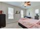 Cozy bedroom featuring a bed with pink floral bedding and a ceiling fan at 6170 Shelbyville Rd, Indianapolis, IN 46237