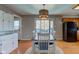 Dining area with wooden floors, stylish lighting, and sliding door access to backyard deck at 6170 Shelbyville Rd, Indianapolis, IN 46237