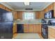 Traditional kitchen with light wood cabinets, black appliances and a window at 6170 Shelbyville Rd, Indianapolis, IN 46237