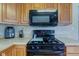 Gas range and microwave with wood cabinets and light countertops in a kitchen at 6170 Shelbyville Rd, Indianapolis, IN 46237