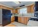 Traditional kitchen with light wood cabinets, black appliances and a window at 6170 Shelbyville Rd, Indianapolis, IN 46237