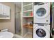 This laundry room includes a modern stackable washer and dryer set and a utility sink at 6170 Shelbyville Rd, Indianapolis, IN 46237