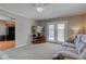 Comfortable living room showcasing a plush sofa, ceiling fan, and access to the backyard at 6170 Shelbyville Rd, Indianapolis, IN 46237