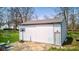Outbuilding with gray roof and a basketball hoop on a concrete patio surrounded by a beautiful lawn with mature trees at 6170 Shelbyville Rd, Indianapolis, IN 46237
