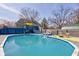 Backyard pool with deck, lounge chairs, outdoor rug, and blue fencing offers a serene outdoor oasis at 6170 Shelbyville Rd, Indianapolis, IN 46237