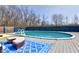 Backyard pool area featuring a deck, lounge seating, rug, and blue fencing, providing a private and comfortable outdoor space at 6170 Shelbyville Rd, Indianapolis, IN 46237