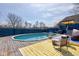 Backyard pool with deck, lounge chairs, outdoor rug, and blue fencing offers a private outdoor oasis for relaxation at 6170 Shelbyville Rd, Indianapolis, IN 46237