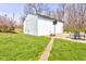 View of the white metal shed and concrete pad with basketball hoop and patio at 6170 Shelbyville Rd, Indianapolis, IN 46237
