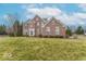 Charming two-story brick home featuring an inviting entrance, well-manicured lawn, and mature trees at 6272 Turnbridge Dr, Avon, IN 46123