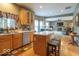 Open-concept kitchen featuring wood cabinetry, an island with seating, and hardwood floors at 6272 Turnbridge Dr, Avon, IN 46123