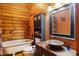 Cozy bathroom with a claw-foot tub, wooden walls, and a vessel sink at 6351 Dixon Rd, Columbus, IN 47201