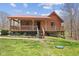 Charming log cabin with a red roof and inviting covered porch at 6351 Dixon Rd, Columbus, IN 47201