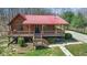 Charming log cabin with a red roof and inviting covered porch at 6351 Dixon Rd, Columbus, IN 47201